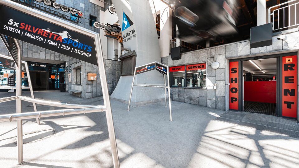 Ein moderner Sportbereich mit Schildern für Verleih und Shop. Die Umgebung ist hell und lädt zu Aktivitäten ein.