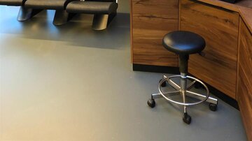 Ein moderner Friseursalon mit mehreren Stühlen und Holzregalen. Die Einrichtung ist minimalistisch und einladend.